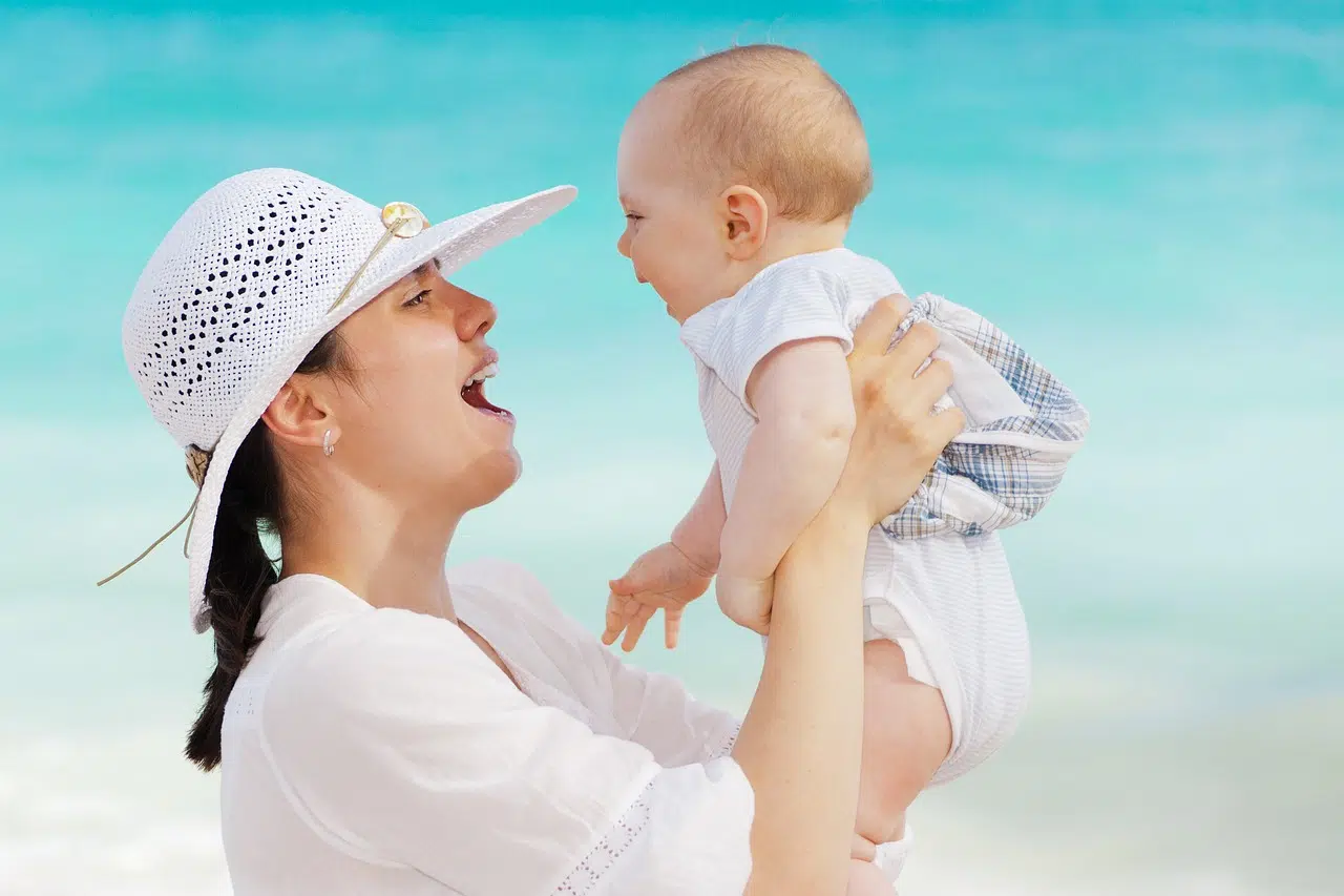 Jeune maman souriante avec son bébé, illustration de la reprise du sport en douceur après l'accouchement