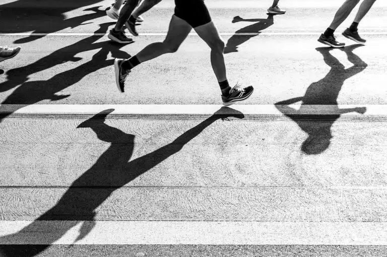 Coureurs sur route pendant un semi-marathon, allure régulière et foulée économique