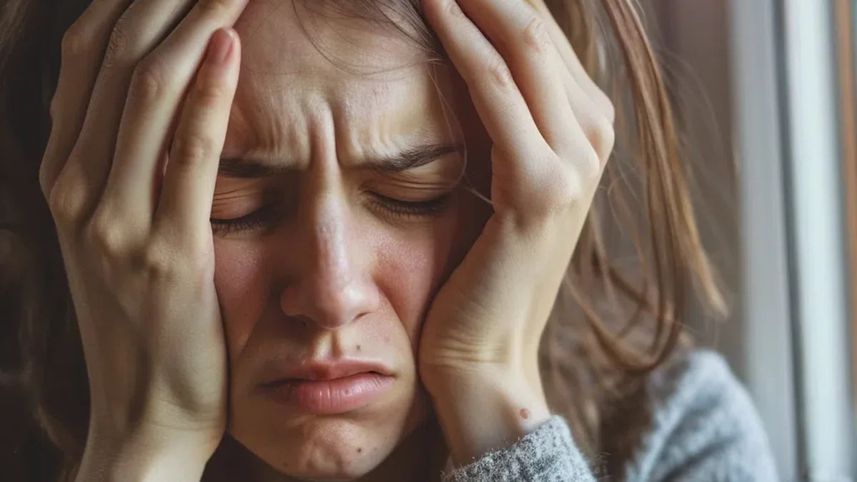 Personne assise, t&ecirc;te entre les mains, illustrant les manifestations du stress chronique au quotidien