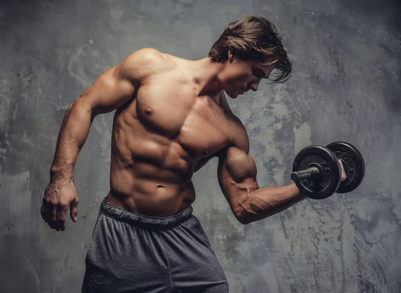 Pratiquant en salle de musculation lors d'une séance de prise de masse musculaire avec charges libres